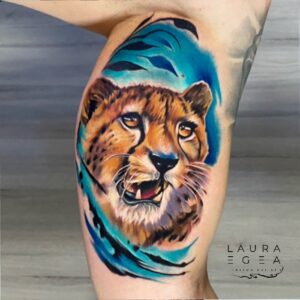 Realistic color tattoo of a cheetah surrounded by blue tones by Laura Egea